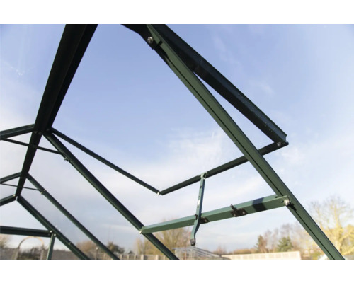 Serre verte en construction, vue intérieure de la structure du cadre sur fond de ciel bleu.