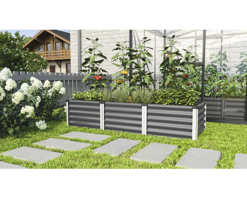 Jardinière surélevée en métal avec des légumes et des herbes aromatiques dans le jardin