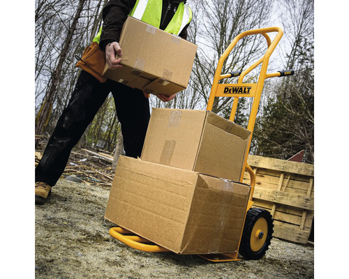 Gelbe Sackkarre mit Kartons beladen, bedient von Person mit Sicherheitsweste