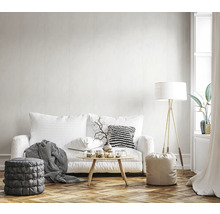 Helles Wohnzimmer mit Sofa, Stehlampe und Dekoration auf einem Holzboden