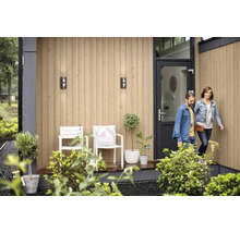Façade de maison avec luminaires extérieurs, chaises, plantes et porte d''entrée