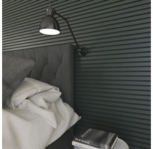 Gros plan d''une chambre à coucher avec lit, table de chevet, livre et applique murale