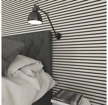 Chambre avec lit, lampe de chevet et mur rayé