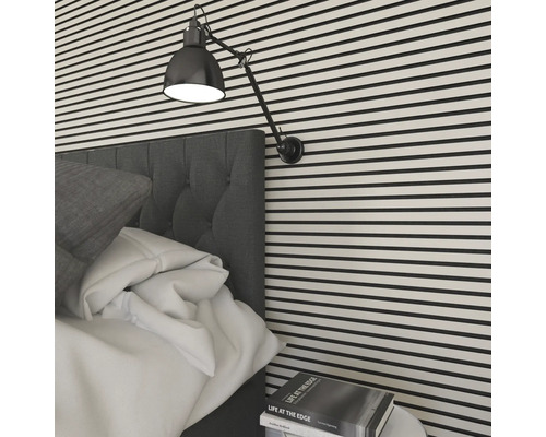 Chambre avec lit, lampe de chevet et mur rayé