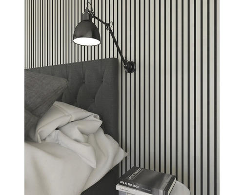 Scène de chambre à coucher avec lit, table de chevet et applique murale devant un mur rayé