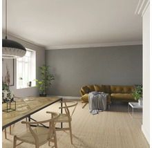 Salon avec table à manger, chaises et canapé devant un mur à rayures horizontales