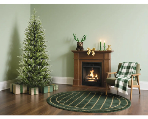 Salon avec sapin de Noël, cadeaux, cheminée et fauteuil