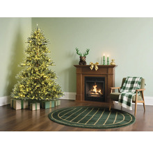 Pièce de Noël avec sapin illuminé, cheminée et fauteuil