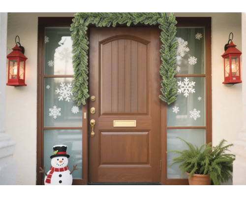 Porte d''entrée décorée avec une guirlande et des autocollants de flocons de neige pour la période des fêtes