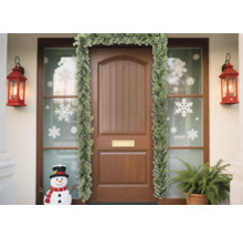 Dekorierte Haustür mit Tannengirlande, Schneeflockenaufklebern und Laternen