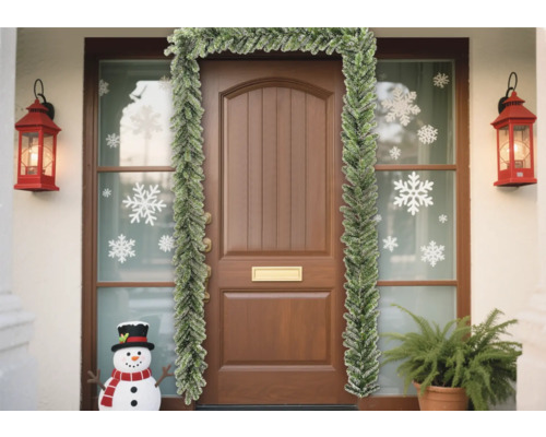 Dekorierte Haustür mit Tannengirlande, Schneeflockenaufklebern und Laternen