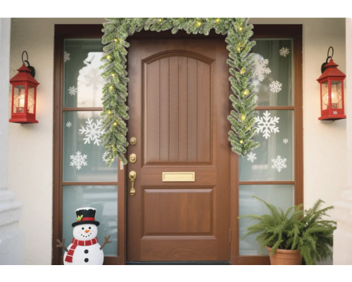Porte d''entrée décorée avec guirlande, lanternes, autocollants de flocons de neige et bonhomme de neige