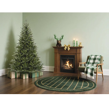 Salon avec sapin de Noël, cheminée et fauteuil pour une ambiance festive