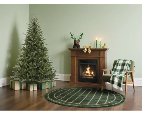 Salon avec sapin de Noël, cheminée et fauteuil pour une ambiance festive