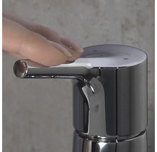 Nahaufnahme eines verchromten Wasserhahns mit Hand, die den Hebel betätigt