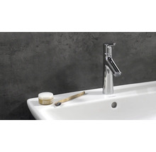 Modernes Badezimmerwaschbecken mit Armatur, Zahnbürste und Kosmetikprodukt