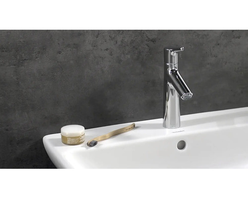 Lavabo de salle de bains moderne avec robinet, brosse à dents et produit cosmétique
