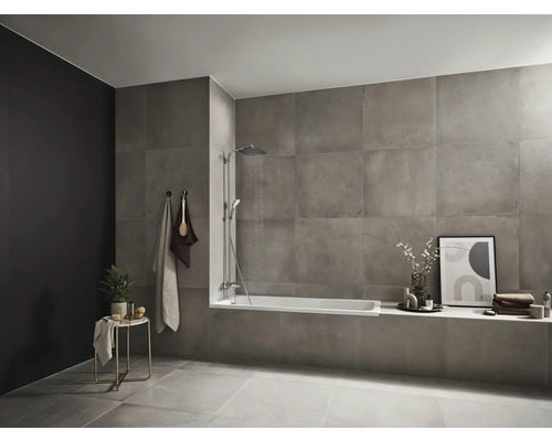 Badezimmer mit Badewanne, Dusche, Handtüchern und Dekoration auf einem Tisch