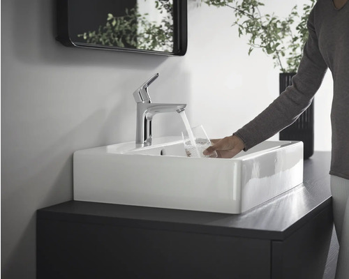 Lavabo avec robinet et personne remplissant un verre d''eau