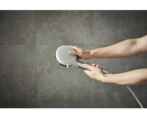 Eine Handbrause wird in der Hand gehalten.