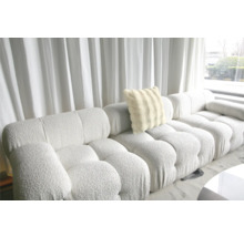 Grand canapé avec coussin moelleux devant une fenêtre avec des rideaux