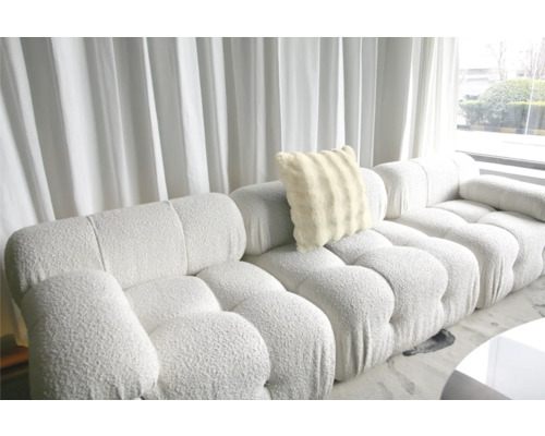 Grand canapé avec coussin moelleux devant une fenêtre avec des rideaux