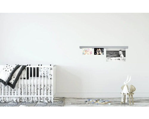 Kinderzimmer mit Babybett, Bilderleiste und Dekoartikeln