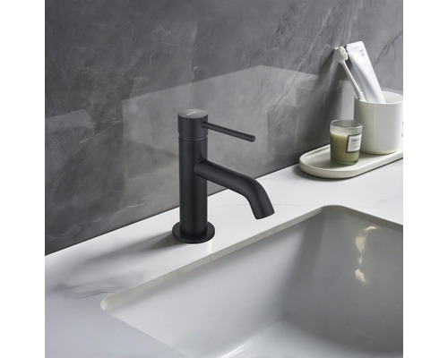 Robinet de lavabo noir sur un lavabo dans une salle de bain.