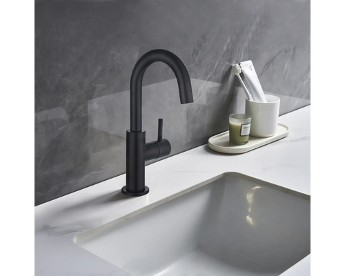 Schwarzer Waschtischmischer neben einem Waschbecken im Badezimmer.