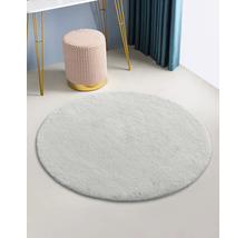 Tapis rond et clair dans une pièce avec tabouret et table.