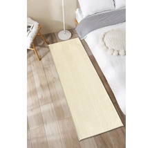 Beige Läufer vor einem Bett auf Holzboden