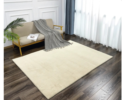 Beiger Teppich in einem hellen Wohnzimmer mit Sofa und Vorhängen