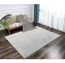 Heller Teppich im Wohnzimmer mit Sofa, Decke und Vorhängen