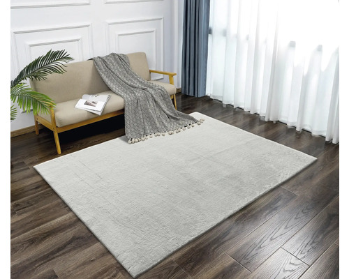 Heller Teppich im Wohnzimmer mit Sofa, Decke und Vorhängen