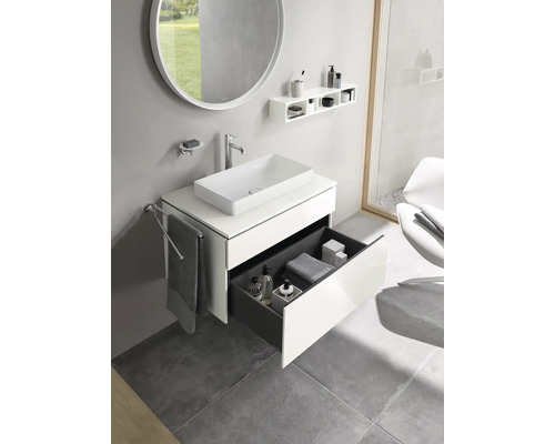 Salle de bains moderne avec lavabo, miroir, étagère et élément de tiroir ouvert.