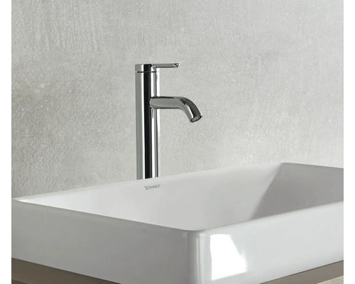 Un robinet de lavabo haut est installé sur une vasque à poser.
