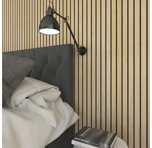 Chambre à coucher avec panneaux acoustiques au mur et une applique murale réglable au-dessus du lit