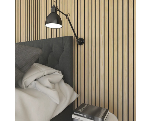 Chambre à coucher avec panneaux acoustiques au mur et une applique murale réglable au-dessus du lit