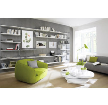 Salon lumineux avec bibliothèque, fauteuil et canapé