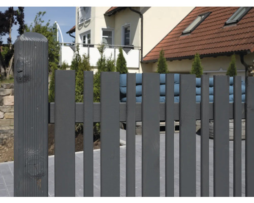 Grauer Holzzaun vor einem Wohnhaus