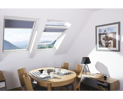 Pièce mansardée lumineuse avec fenêtres de toit, table à manger et décoration