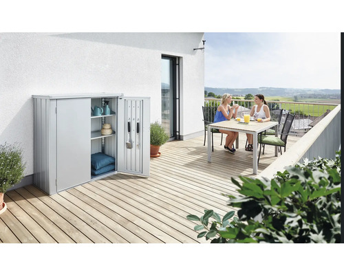 Armoire de jardin en métal avec deux femmes à table sur une terrasse