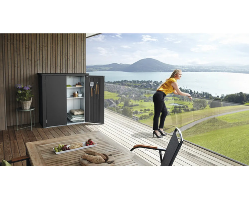 Scène avec un abri de jardin avec des portes ouvertes sur une terrasse avec vue sur le lac