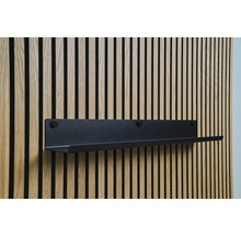 Étagère murale noire sur un mur lambrissé