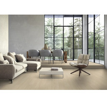 Salon avec canapé, chaises, table et grande fenêtre donnant sur les arbres