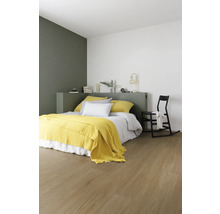 Chambre à coucher avec lit, couverture jaune et plancher en bois