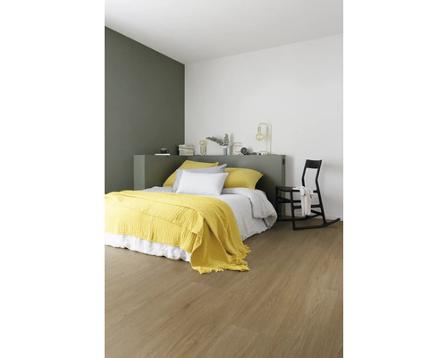 Chambre à coucher avec lit, couverture jaune et plancher en bois