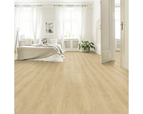 Chambre claire avec sol stratifié imitation bois, lit et rideaux blancs.