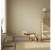 Pièce lumineuse avec des meubles en bois, un banc, une pile de livres et des textiles pour une ambiance chaleureuse.