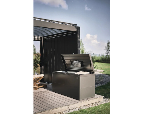 Geöffnete Aufbewahrungsbox auf einer Holzterrasse im Garten.